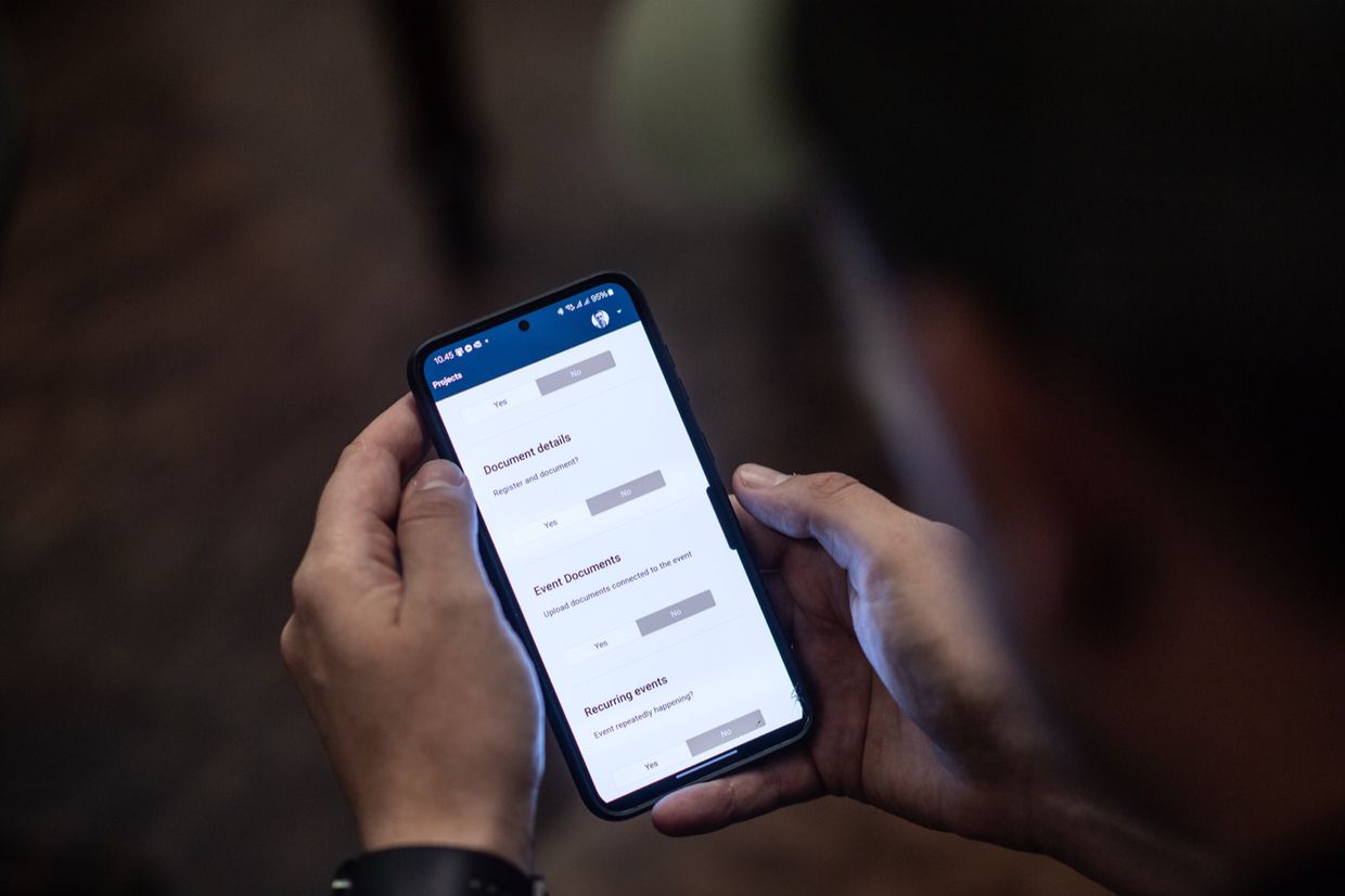 Nærbillede af en telefon der viser en formular med ja/nej-valg