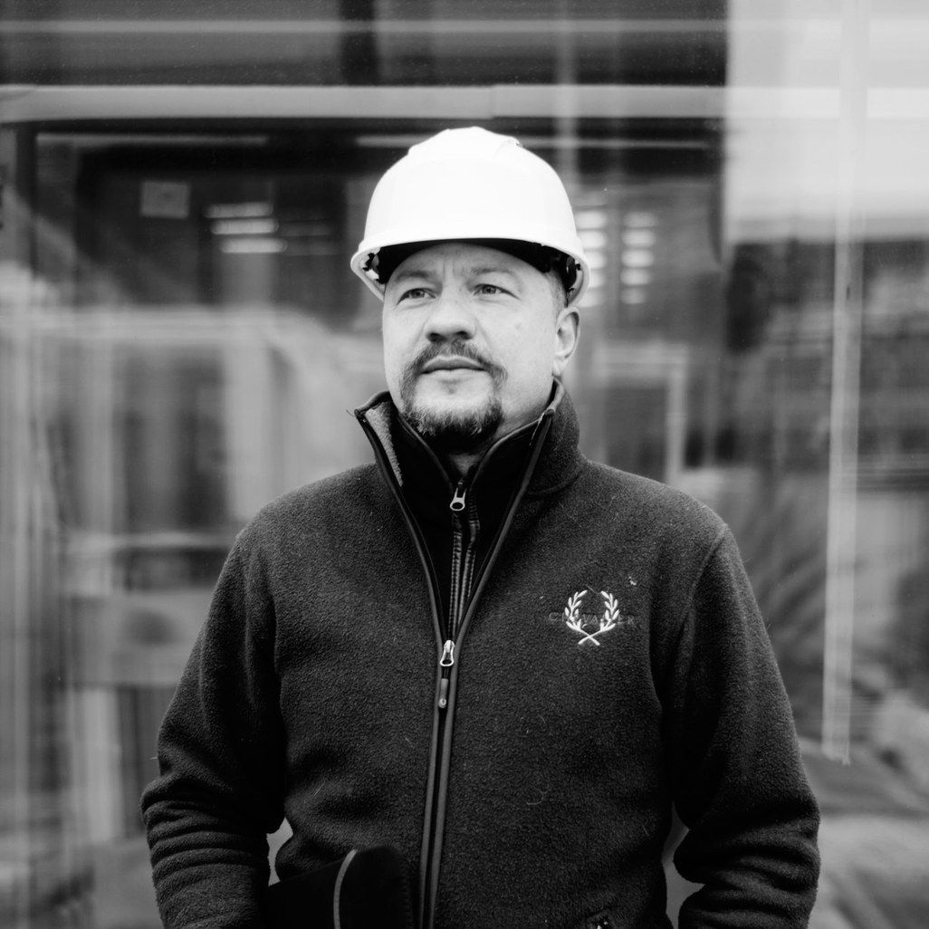 Sort-hvidt portræt af Ulrik Branner med hvid hjelm foran en glasfacade
